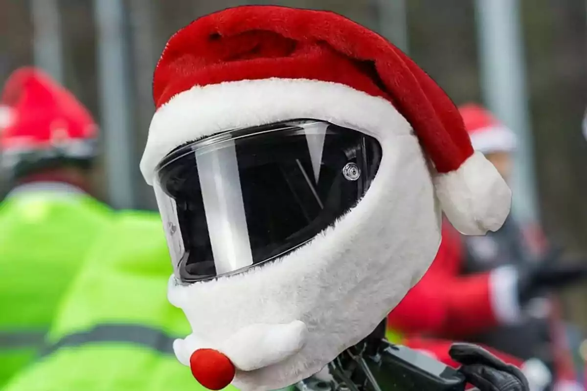 Motorcycle helmet decorated as Santa Claus with a red hat and white beard Motorcycle helmet decorated as Santa Claus with a red hat and white beard