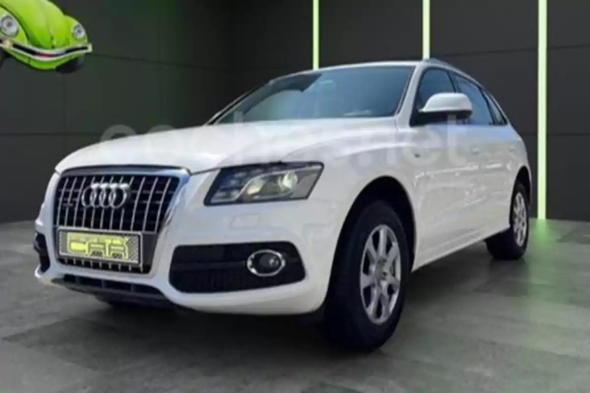Audi SUV blanc estacionat en un lloc tancat amb un fons fosc i un cotxe verd decoratiu a la cantonada superior esquerra Audi SUV blanc estacionat en un lloc tancat amb un fons fosc i un cotxe verd decoratiu a la cantonada superior esquerra