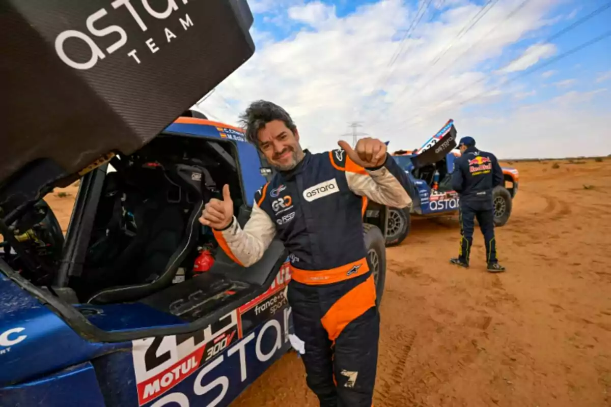 Carlos Checa sonriente con el pulgar arriba junto a su auto en una pista de tierra Carlos Checa sonriente con el pulgar arriba junto a su auto en una pista de tierra