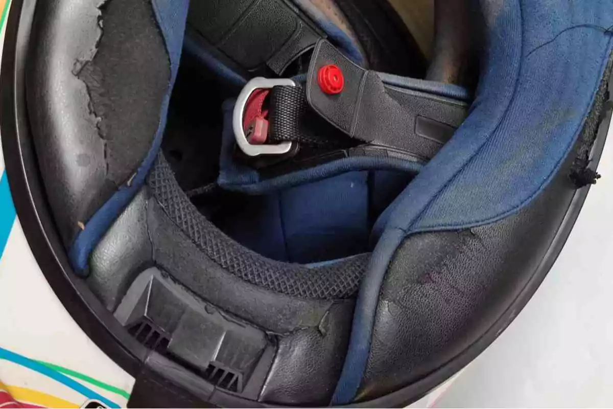 Interior de un casco de motocicleta con desgaste visible en el acolchado y el forro Interior de un casco de motocicleta con desgaste visible en el acolchado y el forro