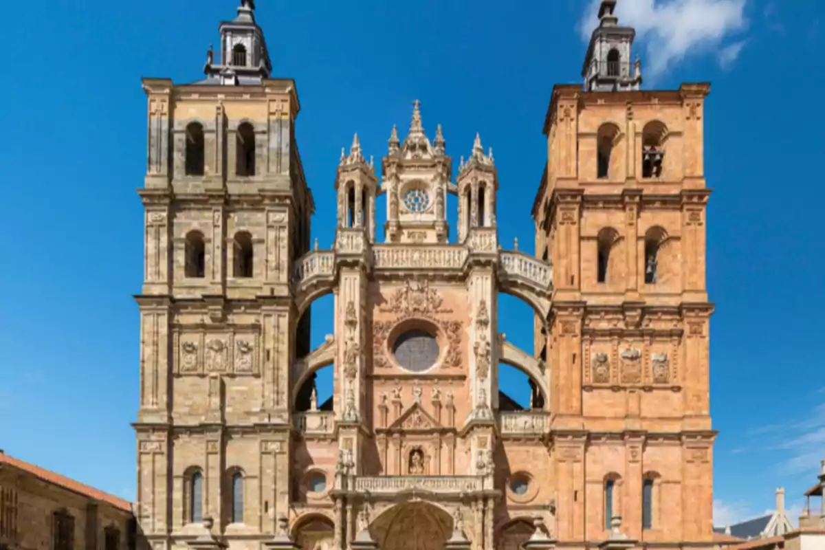 Fachada principal de una catedral de estilo barroco con dos torres y cielo azul de fondo Fachada principal de una catedral de estilo barroco con dos torres y cielo azul de fondo