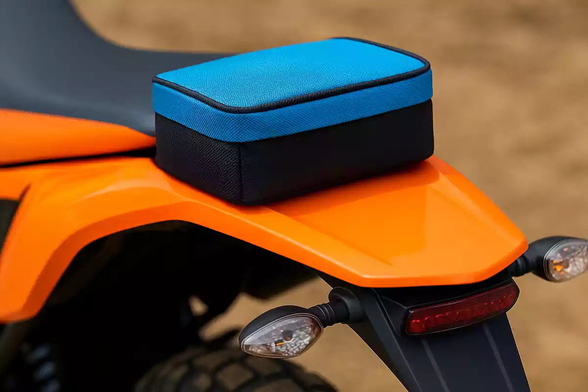 Blue and black rectangular bag placed on the back of an orange motorcycle Blue and black rectangular bag placed on the back of an orange motorcycle
