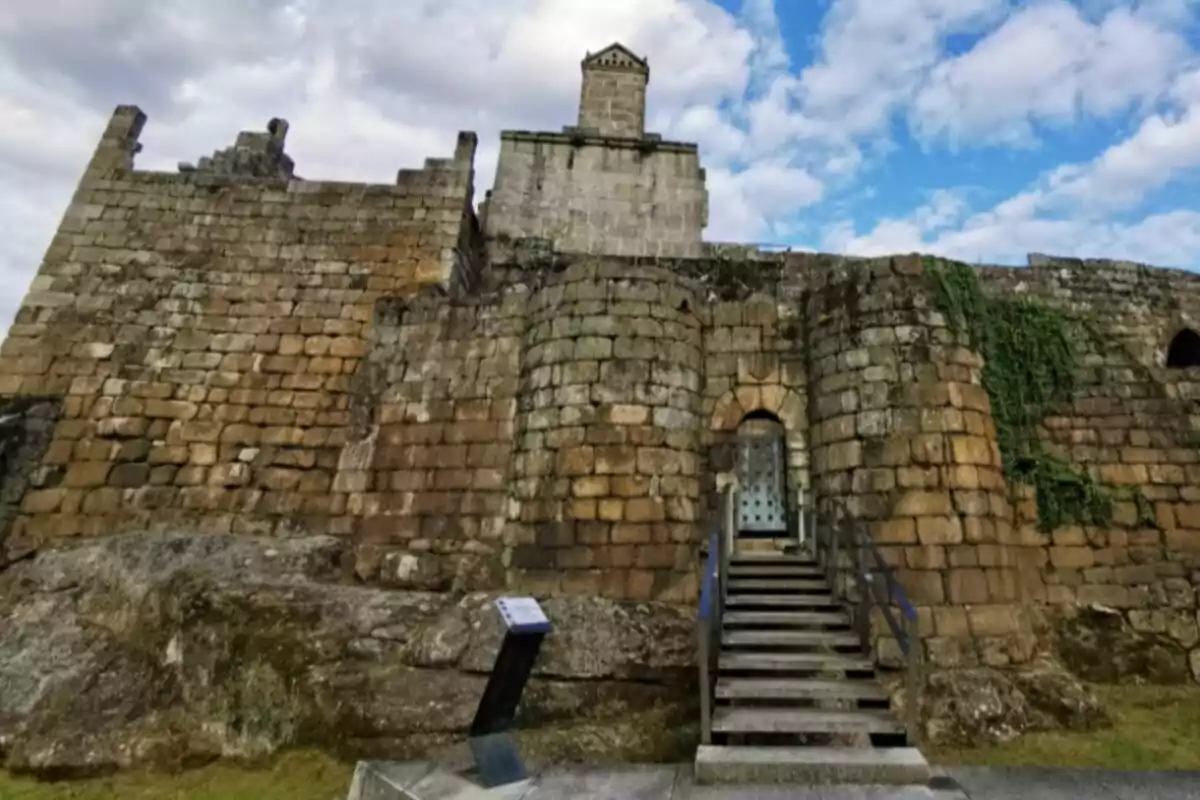 Escala de pedra que condueix a l’entrada d’un castell antic construït amb grans blocs de pedra i vegetació creixent en una de les parets Escala de pedra que condueix a l’entrada d’un castell antic construït amb grans blocs de pedra i vegetació creixent en una de les parets