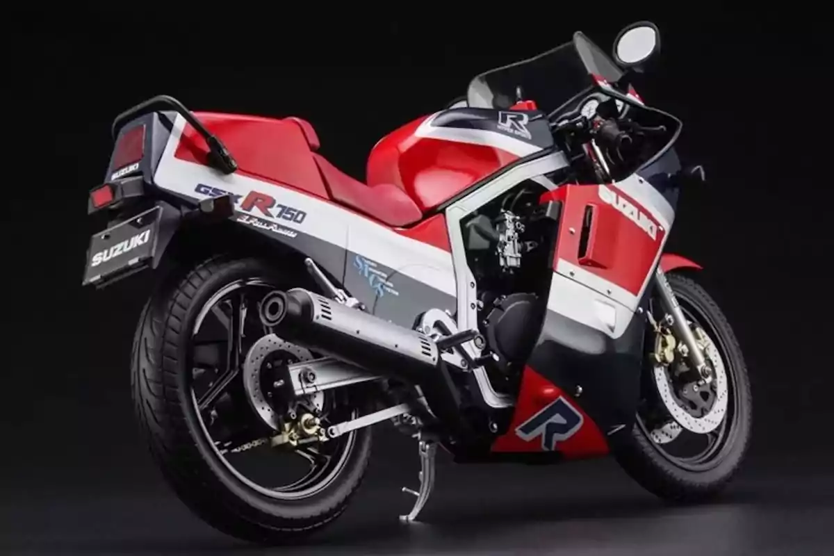 Motocicleta deportiva Suzuki GSX-R750 de color rojo, blanco y azul vista desde un ángulo trasero sobre un fondo negro Motocicleta deportiva Suzuki GSX-R750 de color rojo, blanco y azul vista desde un ángulo trasero sobre un fondo negro