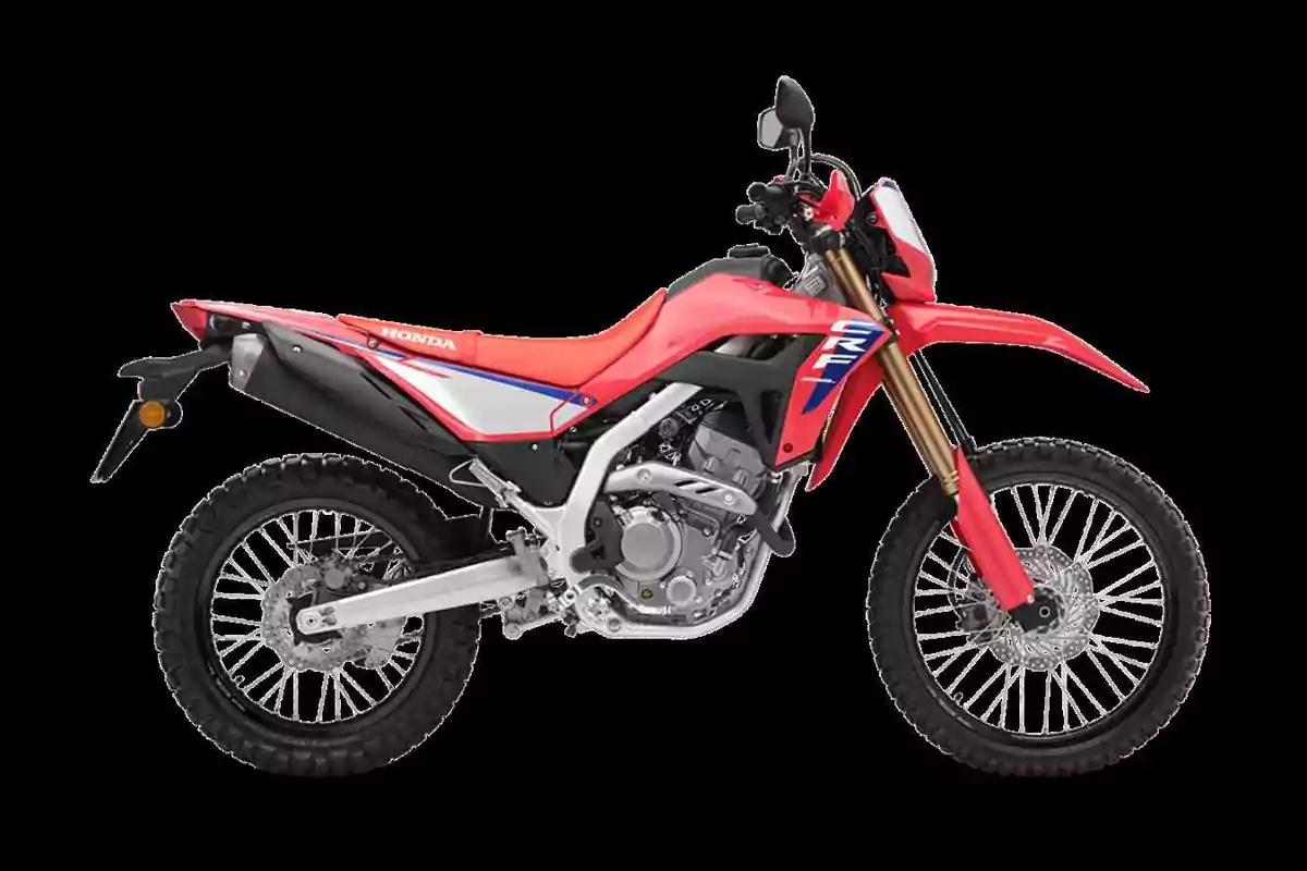 Motocicleta Honda CRF 300L de color rojo vista de lado sobre fondo negro Motocicleta Honda CRF 300L de color rojo vista de lado sobre fondo negro