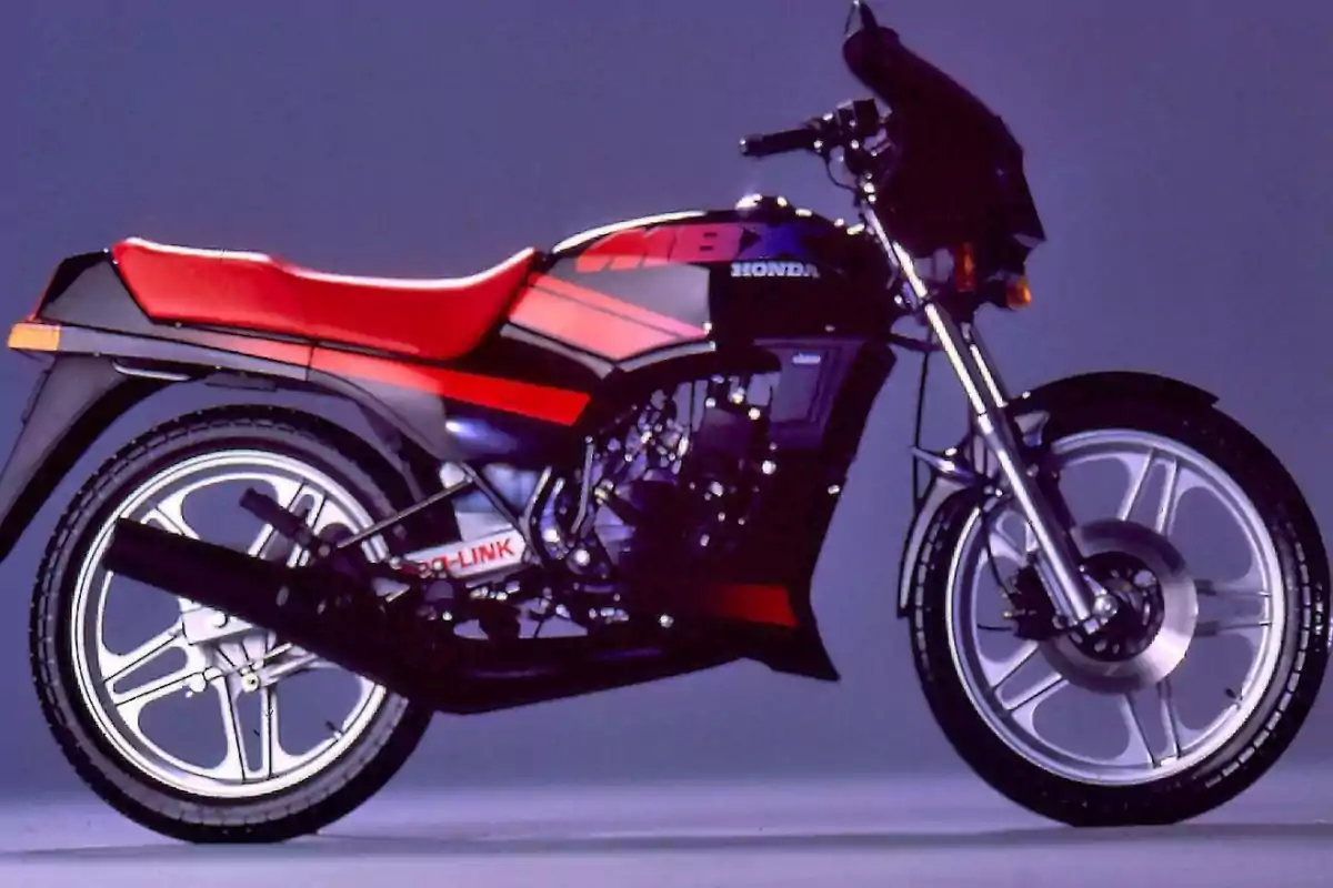 Motocicleta deportiva Honda MBX de color negro con detalles rojos y asiento rojo sobre un fondo liso púrpura Motocicleta deportiva Honda MBX de color negro con detalles rojos y asiento rojo sobre un fondo liso púrpura