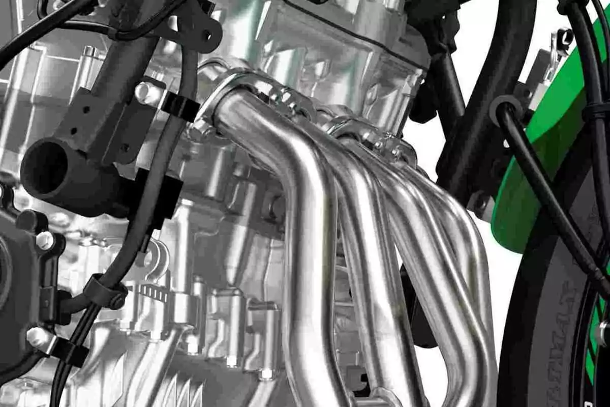 Detalle de un motor de motocicleta con tubos de escape metálicos y cables visibles Detalle de un motor de motocicleta con tubos de escape metálicos y cables visibles