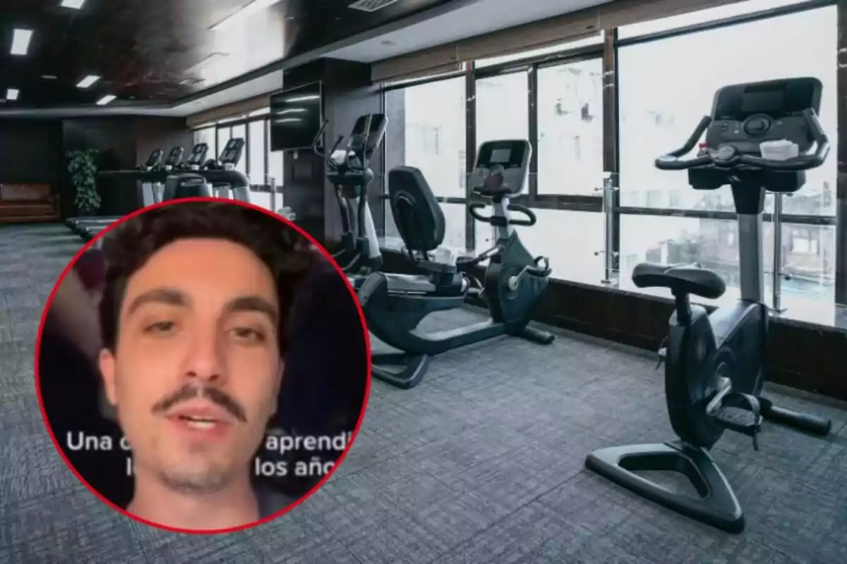 Un gimnasio con varias bicicletas estáticas y una ventana grande al fondo con la imagen de un hombre en un círculo superpuesta en la esquina inferior izquierda