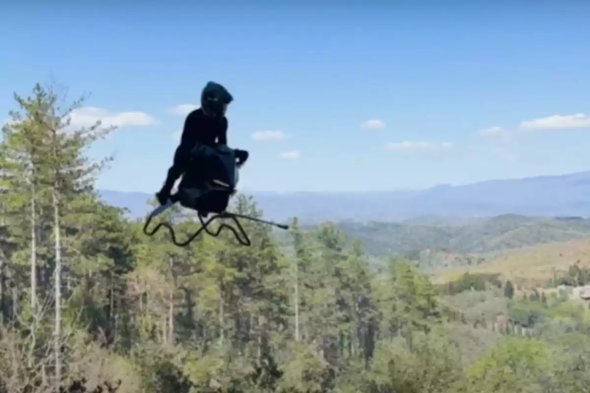 Persona volando sobre un vehículo tipo dron en un paisaje montañoso con árboles y cielo despejado. Persona volando sobre un vehículo tipo dron en un paisaje montañoso con árboles y cielo despejado.
