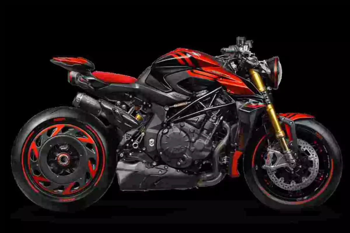 Motocicleta esportiva de color negre amb detalls vermells i daurats sobre un fons negre Motocicleta esportiva de color negre amb detalls vermells i daurats sobre un fons negre