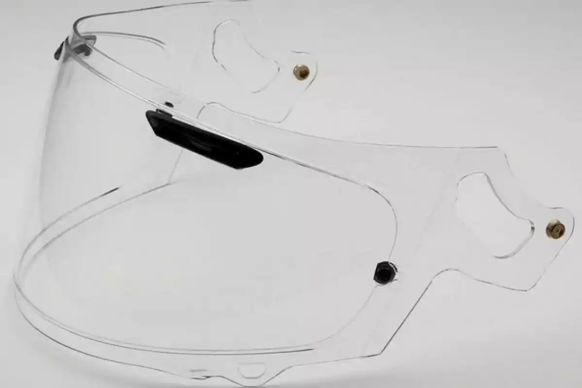 Transparent polycarbonate visor for motorcycle helmet on white background Transparent polycarbonate visor for motorcycle helmet on white background