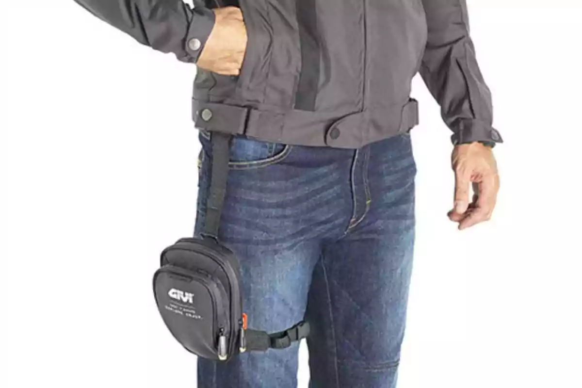 Person wearing a gray jacket and jeans with a black bag strapped to their left thigh Person wearing a gray jacket and jeans with a black bag strapped to their left thigh