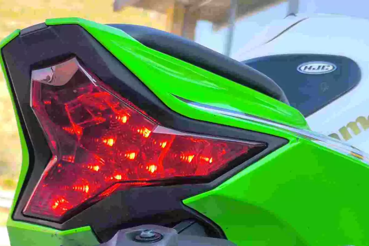Luz trasera encendida de una motocicleta deportiva verde Luz trasera encendida de una motocicleta deportiva verde