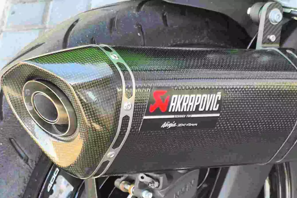 Escape de motocicleta Akrapovic de fibra de carbono con llanta trasera visible Escape de motocicleta Akrapovic de fibra de carbono con llanta trasera visible