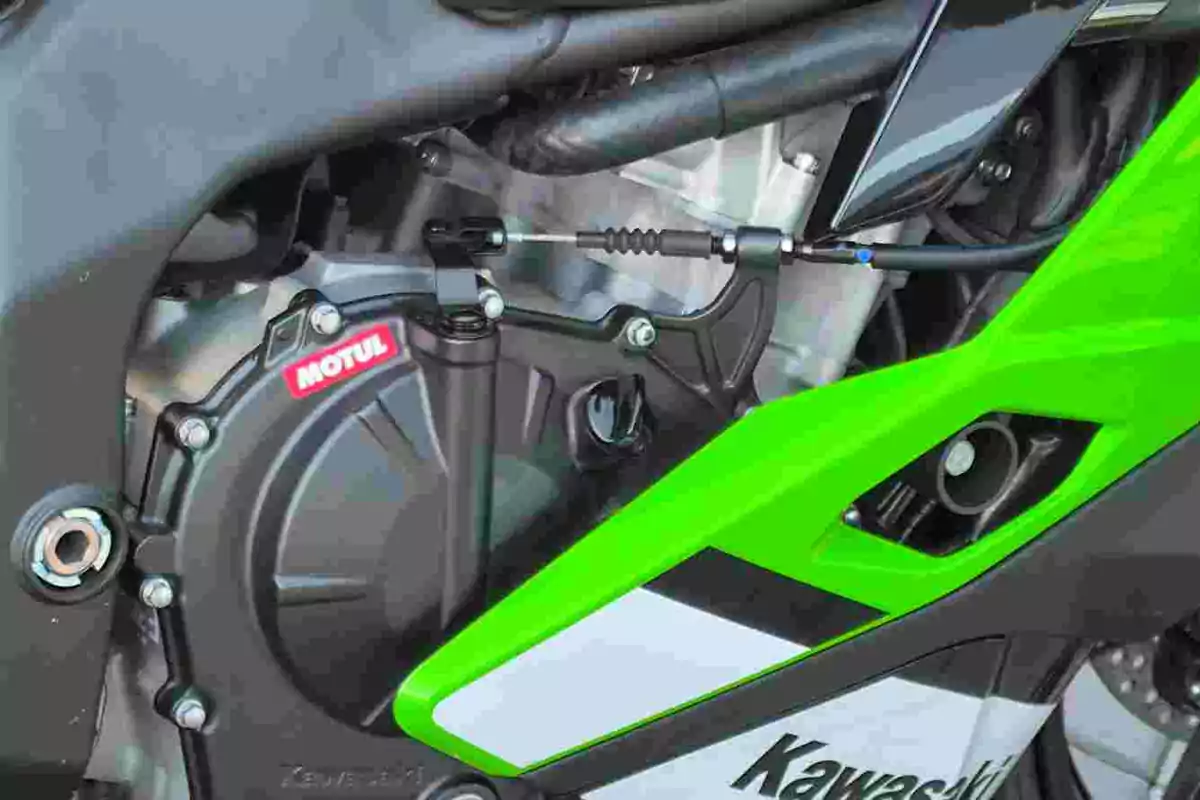 Detalle del motor de una motocicleta Kawasaki con carenado verde y etiqueta Motul visible Detalle del motor de una motocicleta Kawasaki con carenado verde y etiqueta Motul visible
