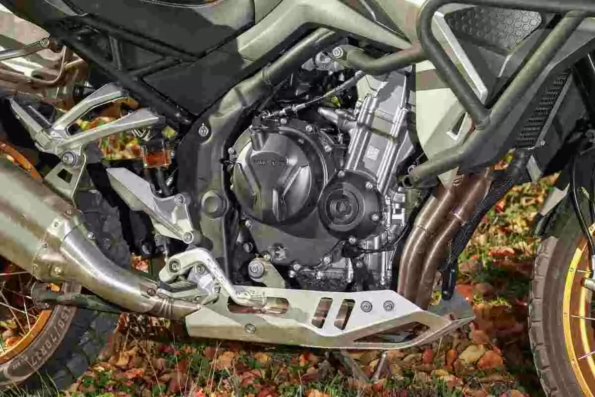 Detalle del motor y chasis de una motocicleta sobre hojas secas Detalle del motor y chasis de una motocicleta sobre hojas secas