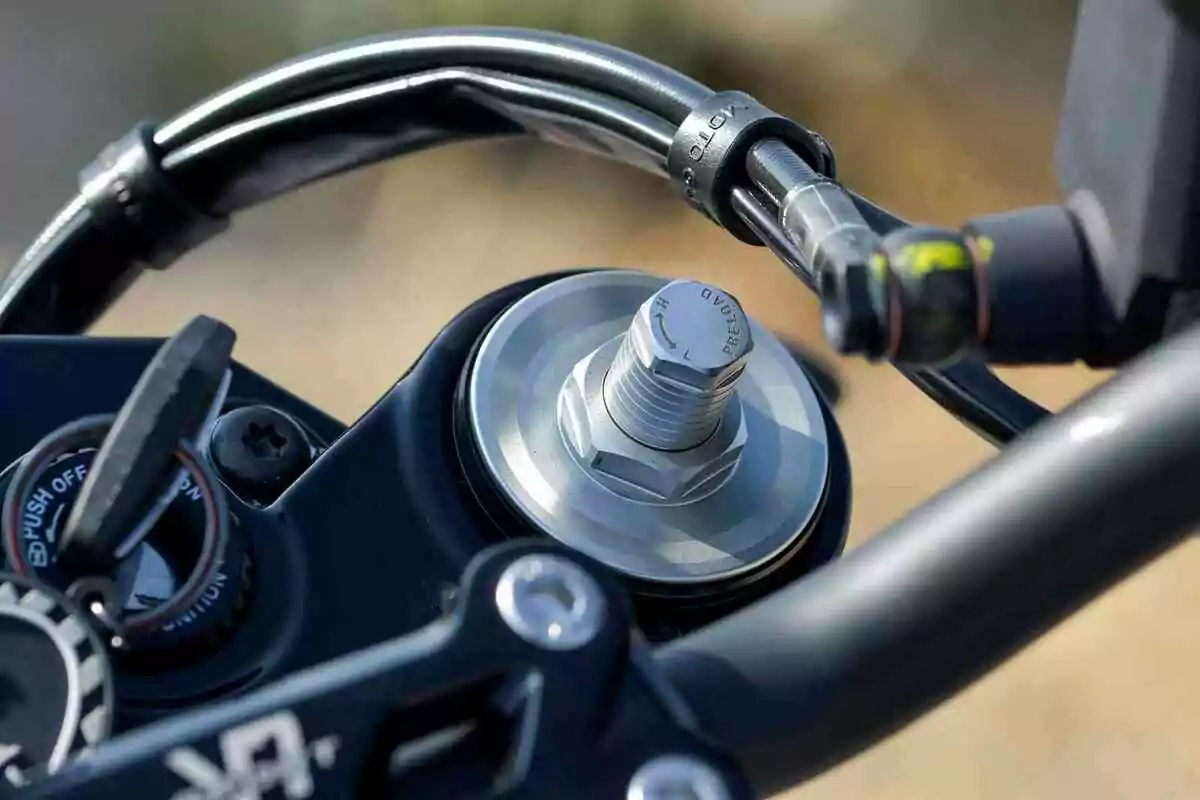 Detalle del manillar de una motocicleta mostrando la llave en el encendido y el ajuste de la suspensión delantera Detalle del manillar de una motocicleta mostrando la llave en el encendido y el ajuste de la suspensión delantera