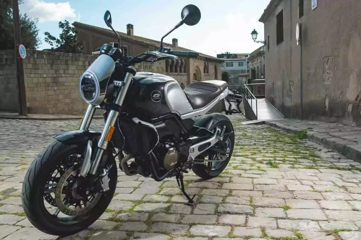 Motocicleta moderna estacionada sobre una calle empedrada en un entorno urbano antiguo Motocicleta moderna estacionada sobre una calle empedrada en un entorno urbano antiguo