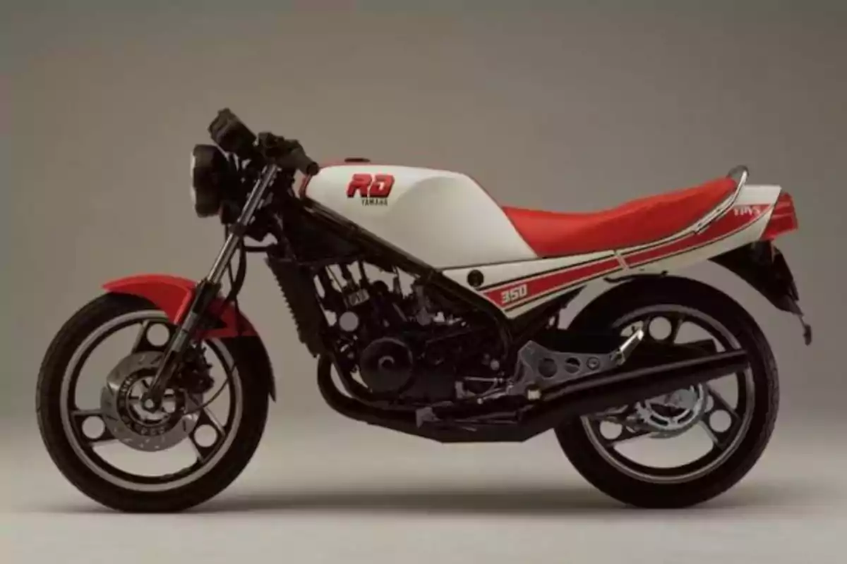 Motocicleta deportiva clásica Yamaha RD 350 con asiento y detalles en rojo sobre fondo neutro Motocicleta deportiva clásica Yamaha RD 350 con asiento y detalles en rojo sobre fondo neutro