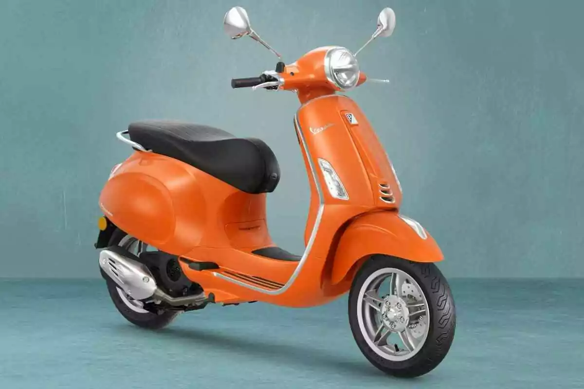 Motocicleta tipus scooter de color taronja amb seient negre sobre un fons blau clar Motocicleta tipus scooter de color taronja amb seient negre sobre un fons blau clar
