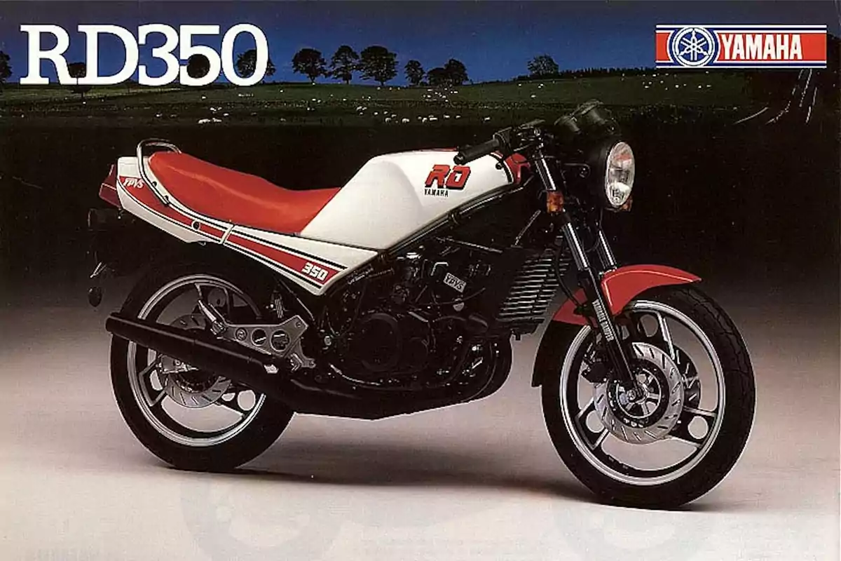 Motocicleta Yamaha RD350 de color blanco con rojo y detalles en negro sobre un fondo oscuro con el logo de Yamaha en la esquina superior derecha Motocicleta Yamaha RD350 de color blanco con rojo y detalles en negro sobre un fondo oscuro con el logo de Yamaha en la esquina superior derecha