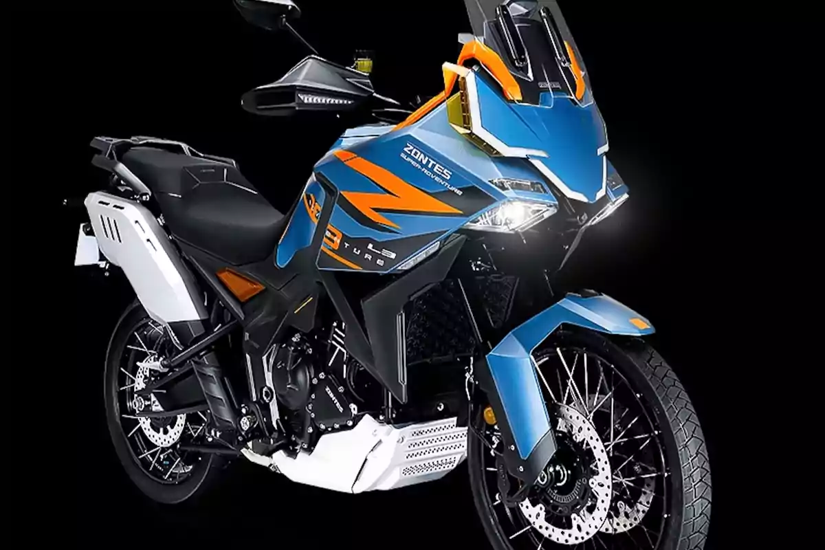Motocicleta deportiva de aventura en color azul con detalles naranjas y negros sobre fondo negro Motocicleta deportiva de aventura en color azul con detalles naranjas y negros sobre fondo negro