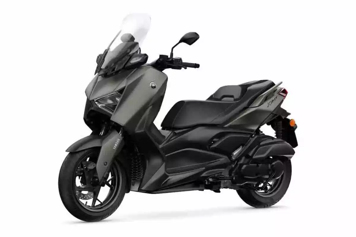 Motocicleta tipo scooter de color gris con parabrisas y asiento doble sobre fondo blanco Motocicleta tipo scooter de color gris con parabrisas y asiento doble sobre fondo blanco