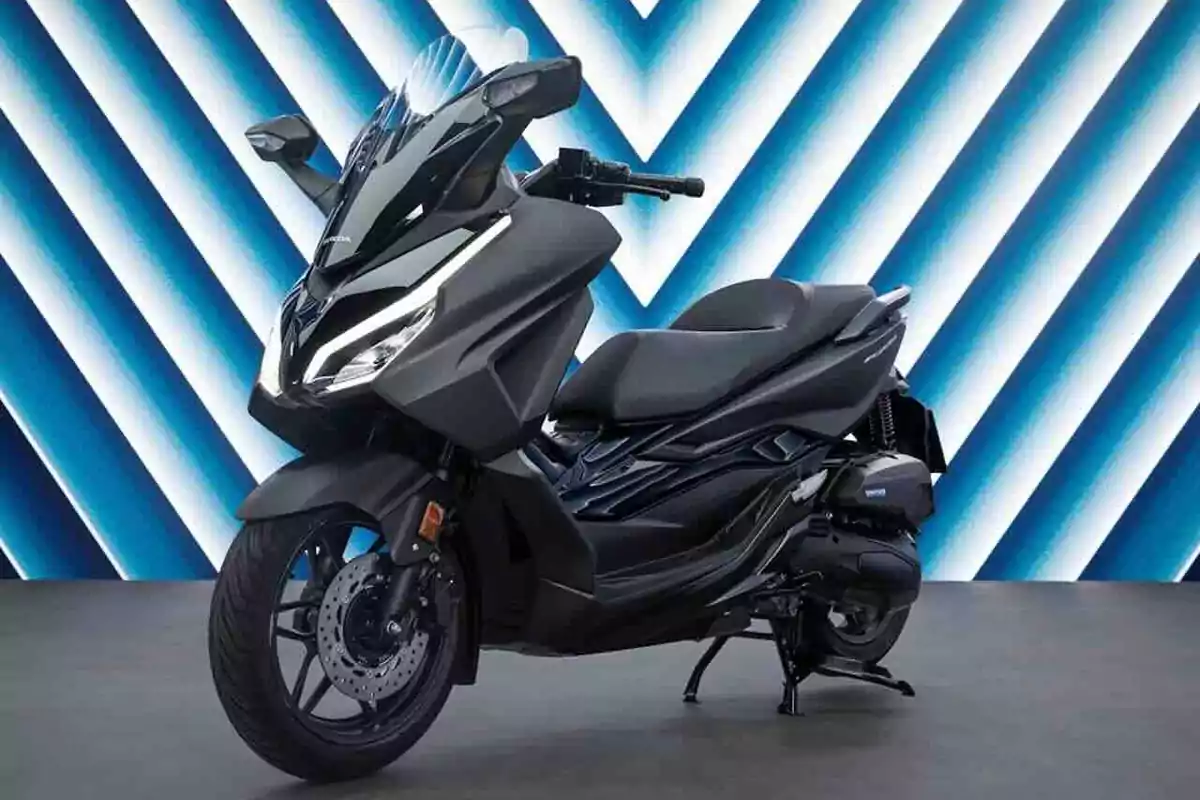 Motocicleta negra tipo scooter sobre un fondo con líneas en zigzag azules y blancas Motocicleta negra tipo scooter sobre un fondo con líneas en zigzag azules y blancas
