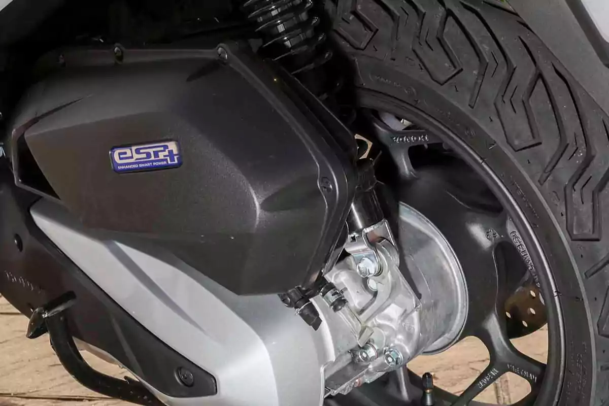 Detalle del motor y la llanta trasera de una motocicleta con la insignia eSP+ Detalle del motor y la llanta trasera de una motocicleta con la insignia eSP+