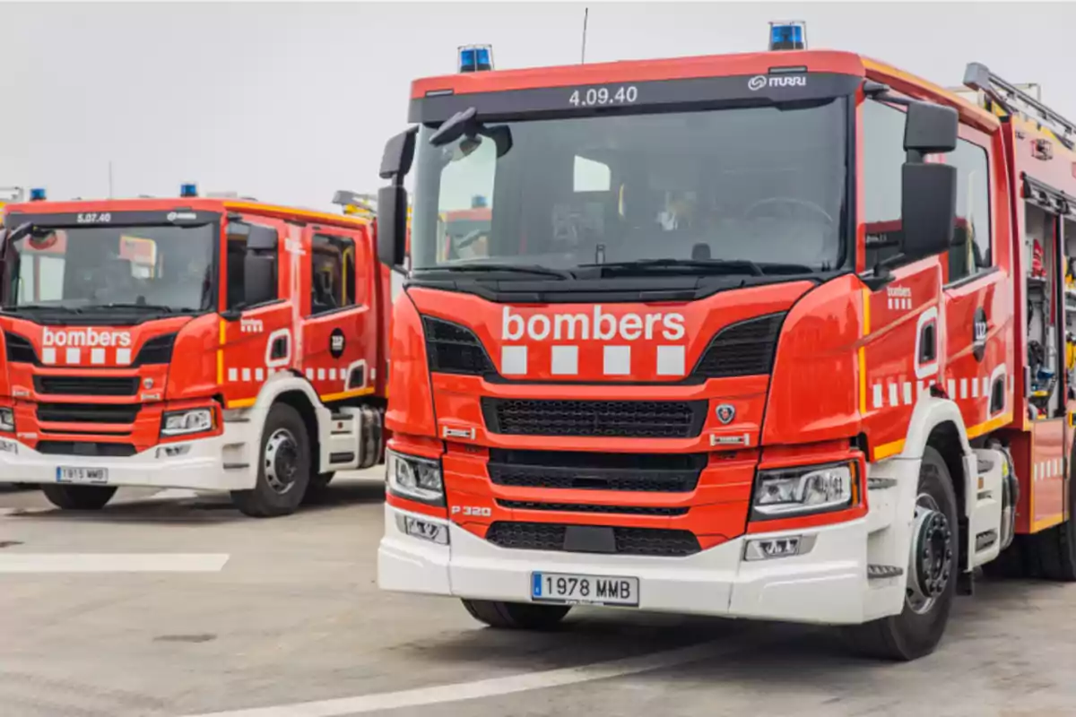 Dos camiones de bomberos rojos estacionados en un área pavimentada. Dos camiones de bomberos rojos estacionados en un área pavimentada.