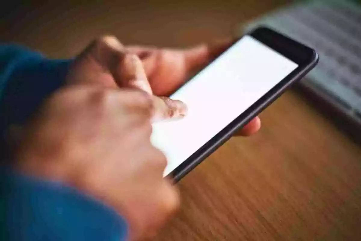 Una persona usando un móvil con la pantalla en blanco